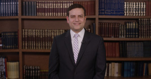 Screenshot of Professor Wimpfheimer from the course videos in front of Talmud Books in the Hillel Library 